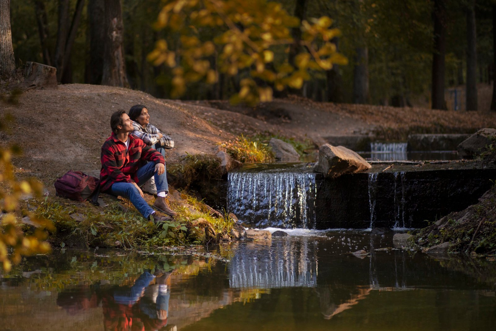 full-shot-couple-sitting-by-river